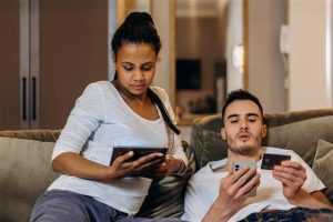 Persoon die slim online winkelen voor essentials doet met laptop en creditcard op achtergrond